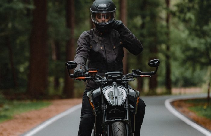man in black jacket riding motorcycle on road during daytime